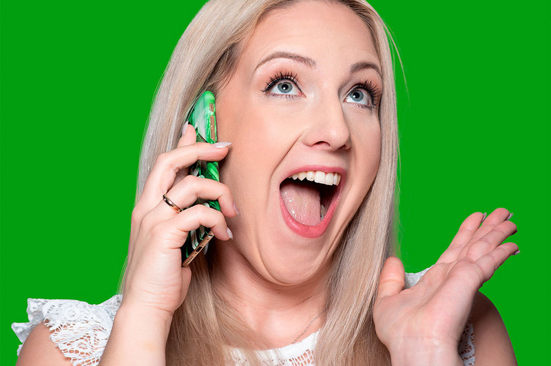 junge Frau telefoniert mit erfreutem Gesichtsausdruck grüner Hintergrund