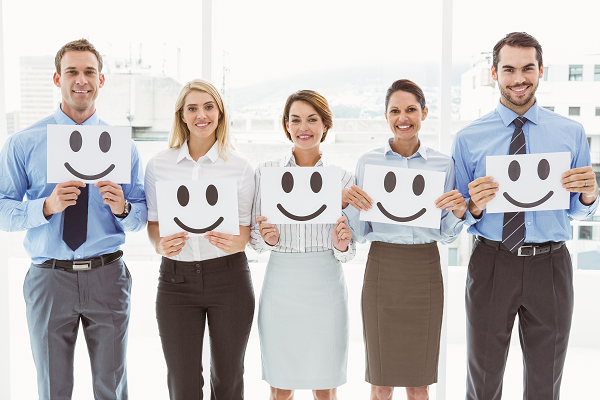 Fünf Business Personen halten Smiley in Händen